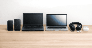 Elektronische Geräte wie Smartphones, Laptops und Kopfhörer auf einem Schreibtisch angeordnet, als visuelle Darstellung für Technologie-Tipps und digitale Nutzung im Alltag.